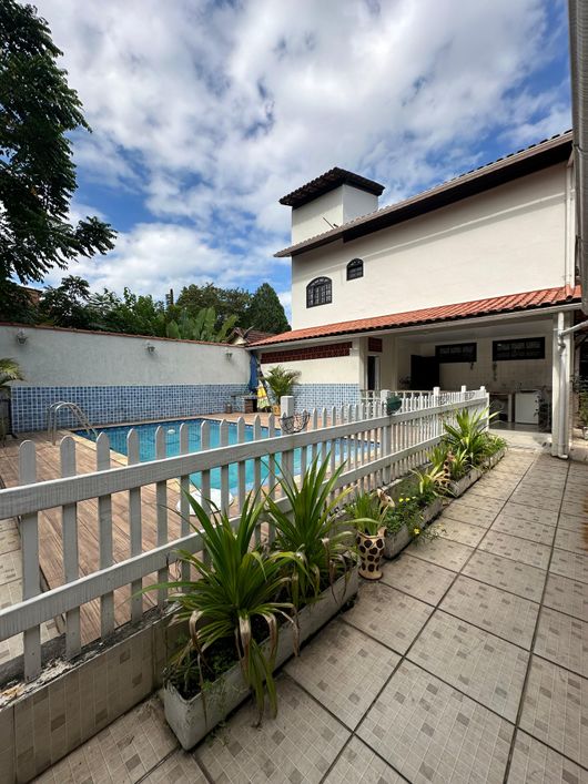 Casa com fachada imponente colonial, possuindo 2 fênix na calçada.